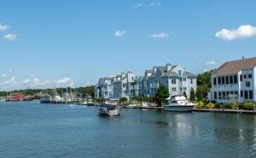 Alt: A river with houses on the side, a sight you will see when moving to Connecticut.