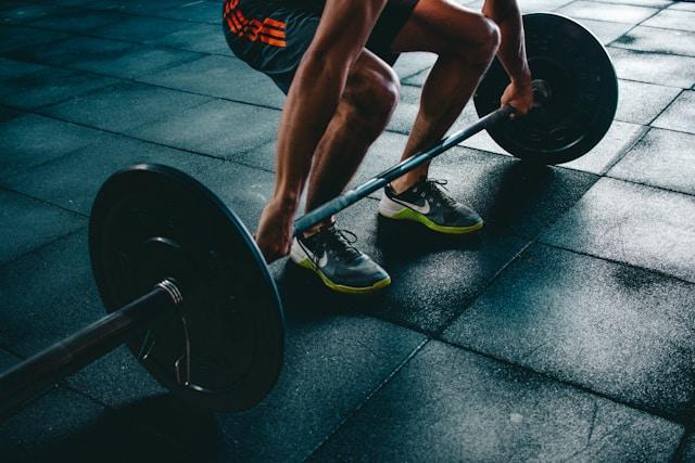 Close-up of a man lifting big weights in a gym